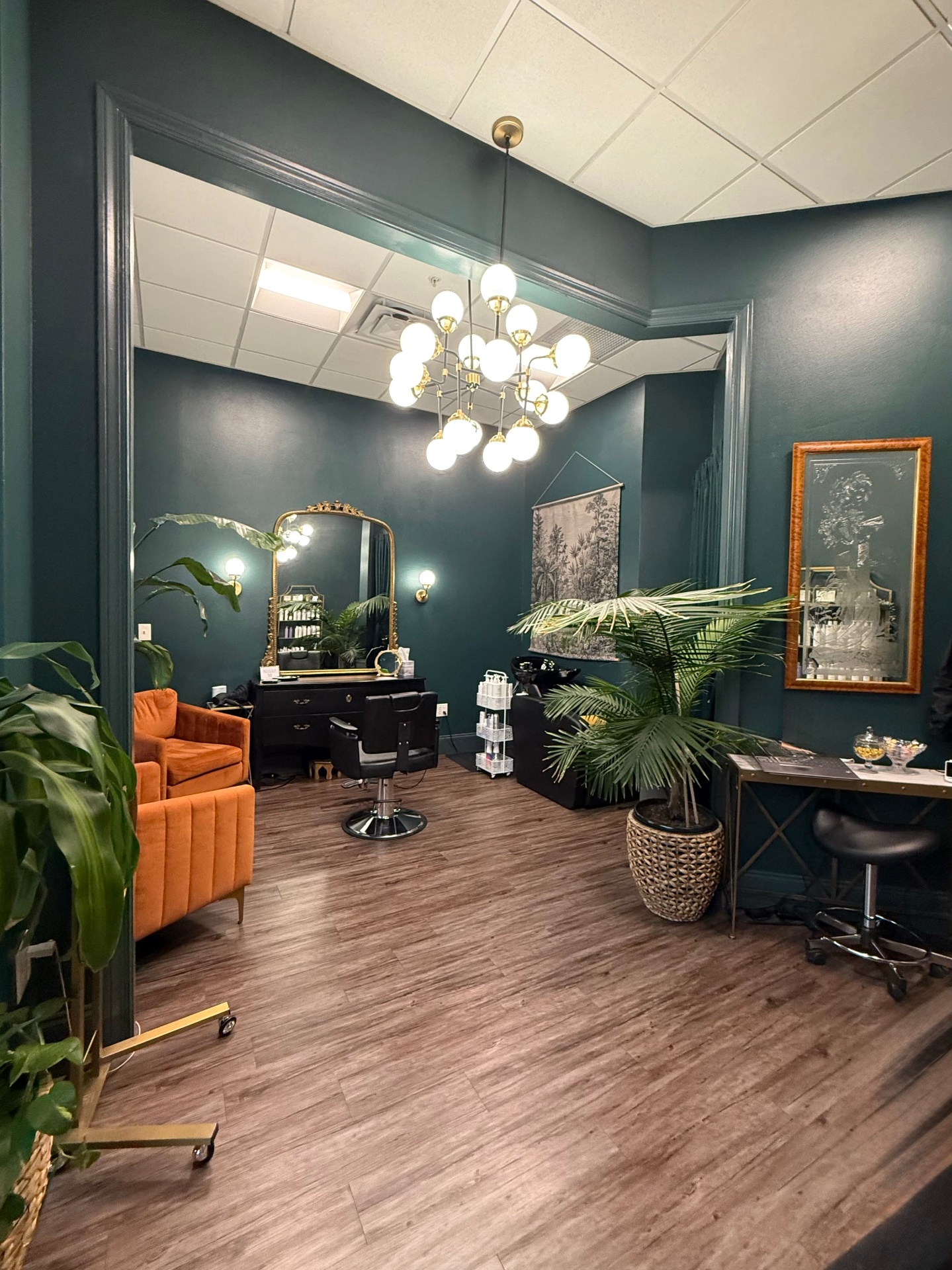 Spring Factor Studio interior — deep green private suite with brass chandelier and gold mirror